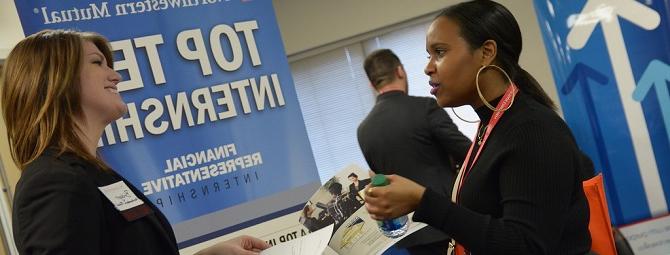 Student and employer connecting at a job fair.