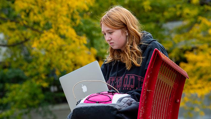 学生在外面使用笔记本电脑